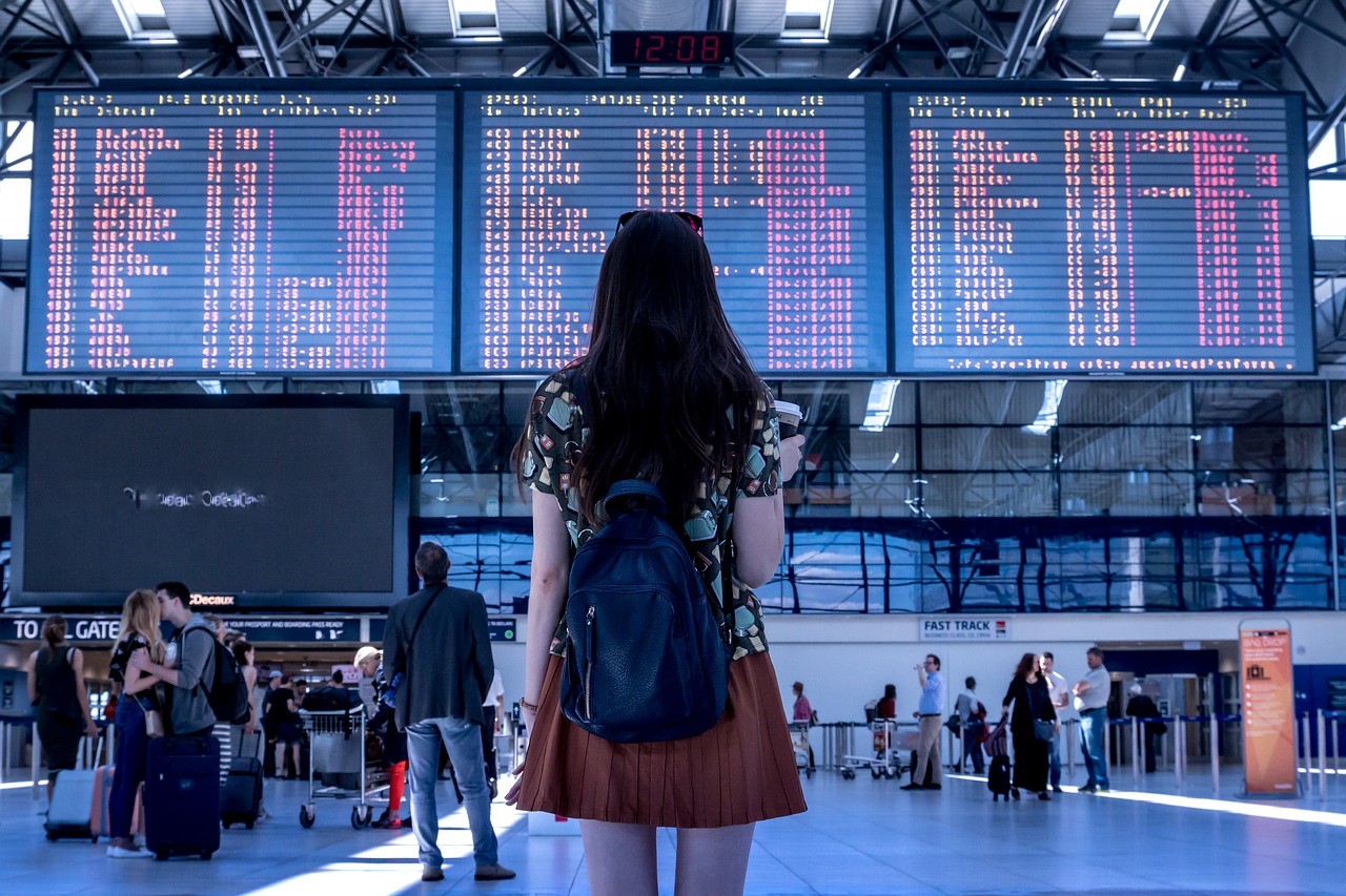 Girl in Front of Airport Signs