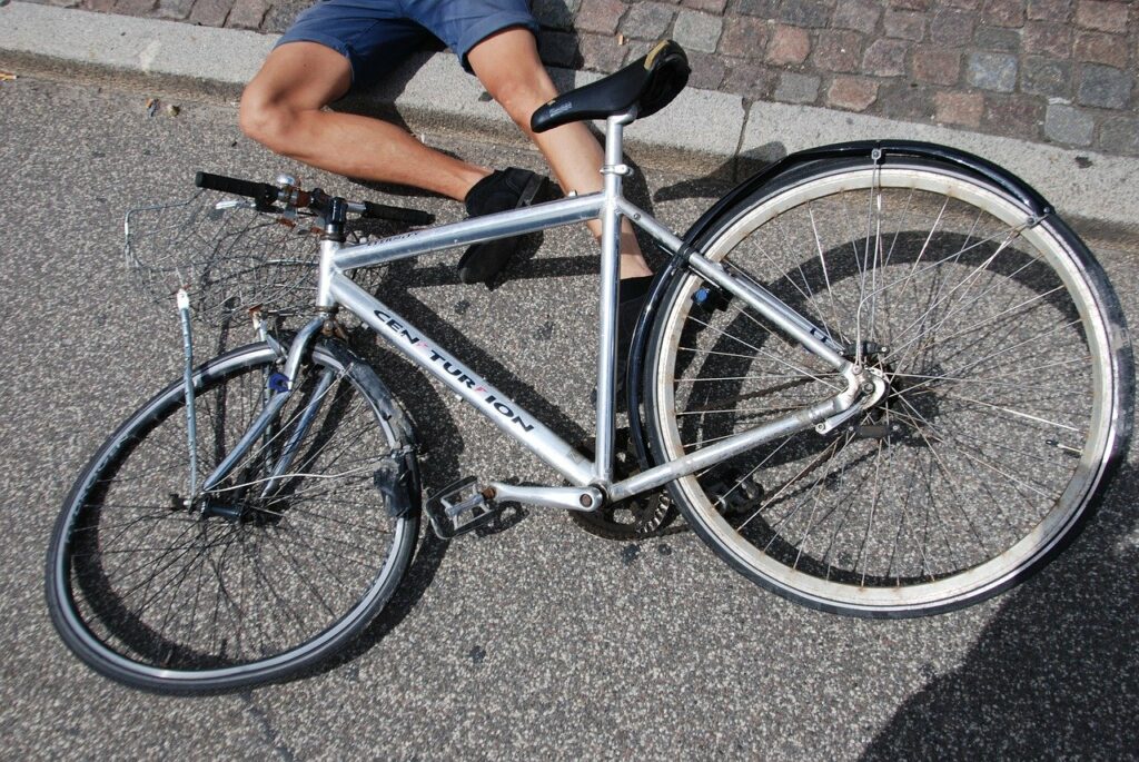 Bike crash with person laying on street