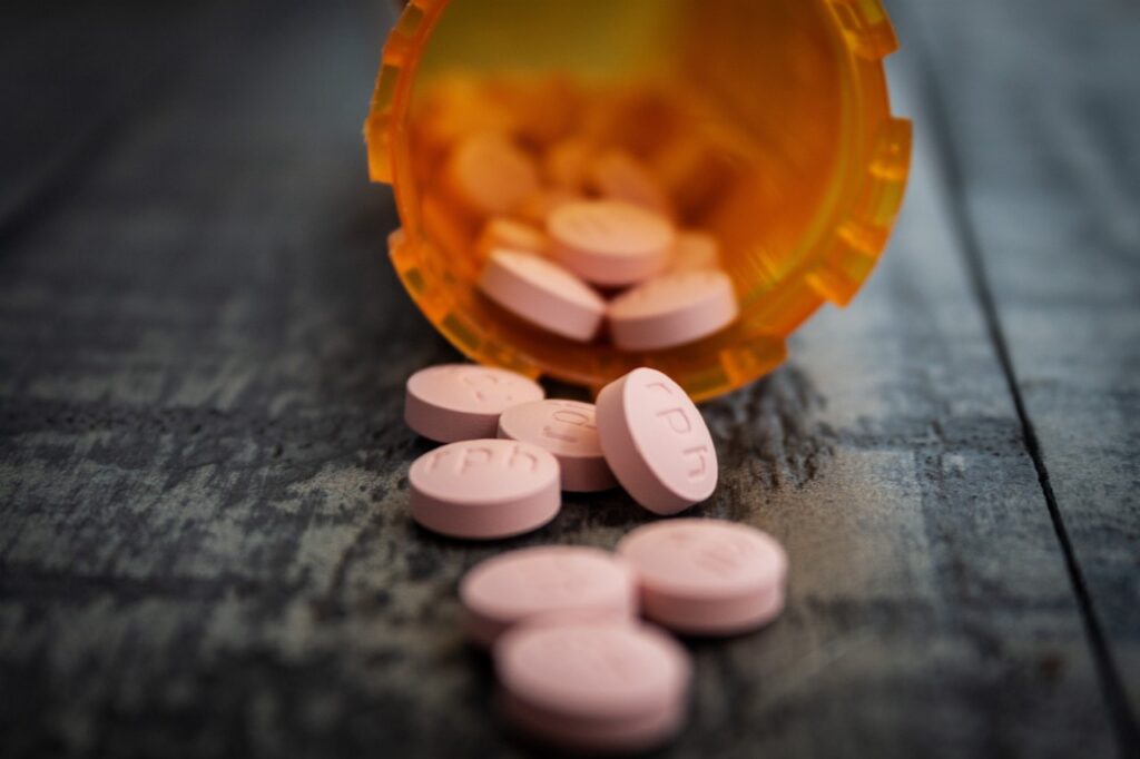 White pills spilling out of pill bottle