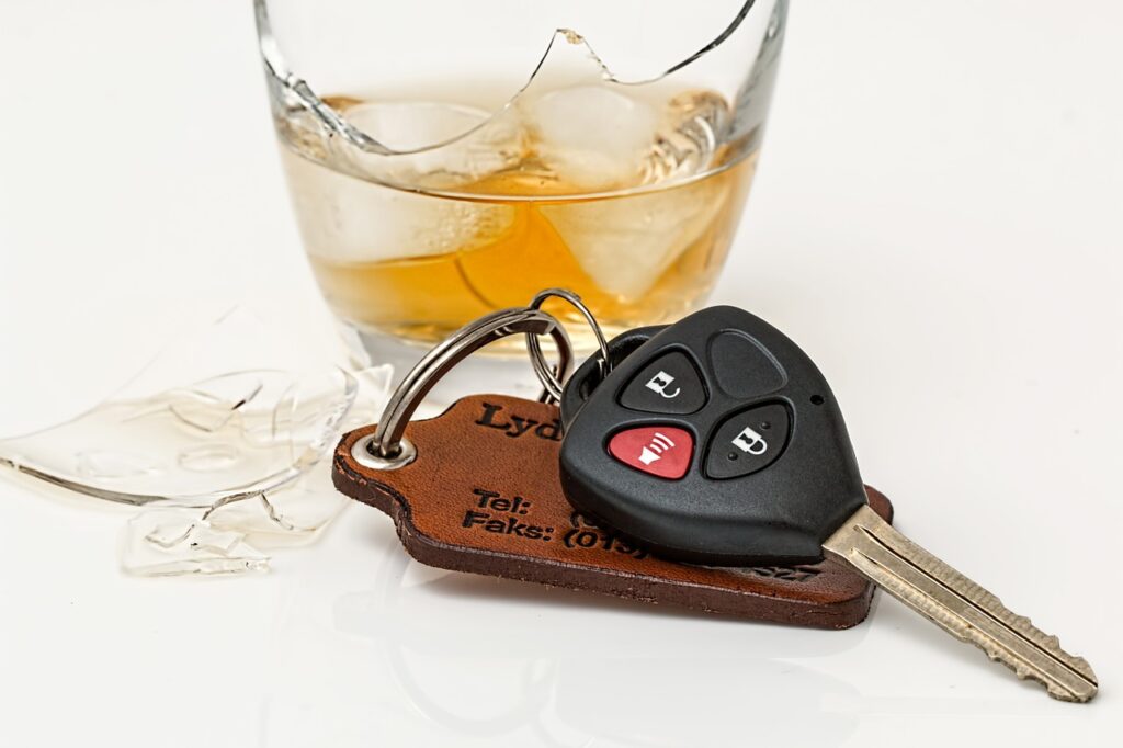 Alcoholic drink in broken glass and car keys