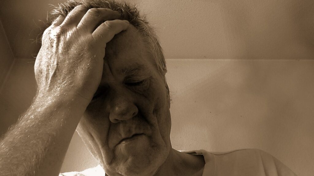 Older man with head resting in head