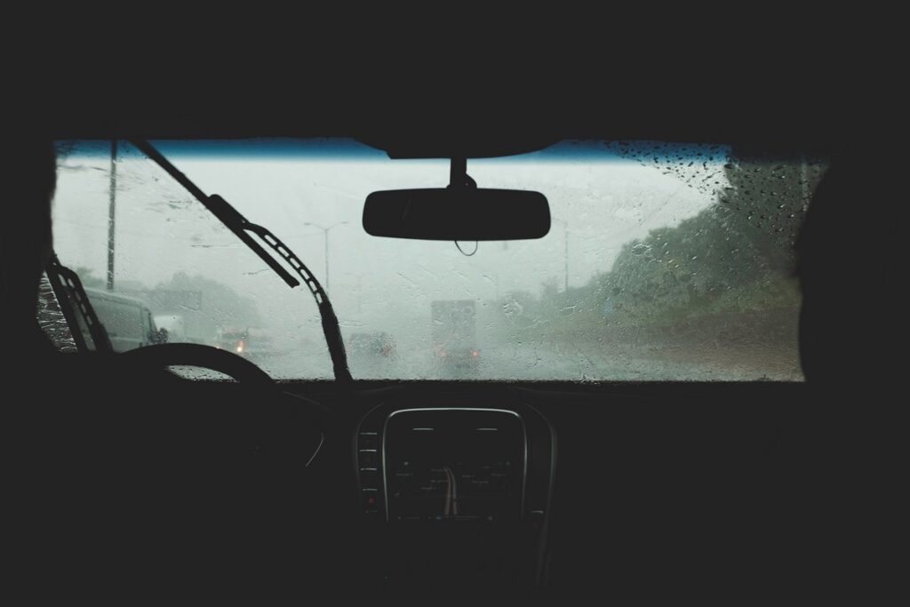Looking out a fogged up car window onto a rainy road