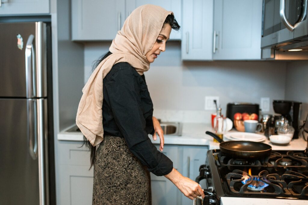 Woman cooking on gas stove.