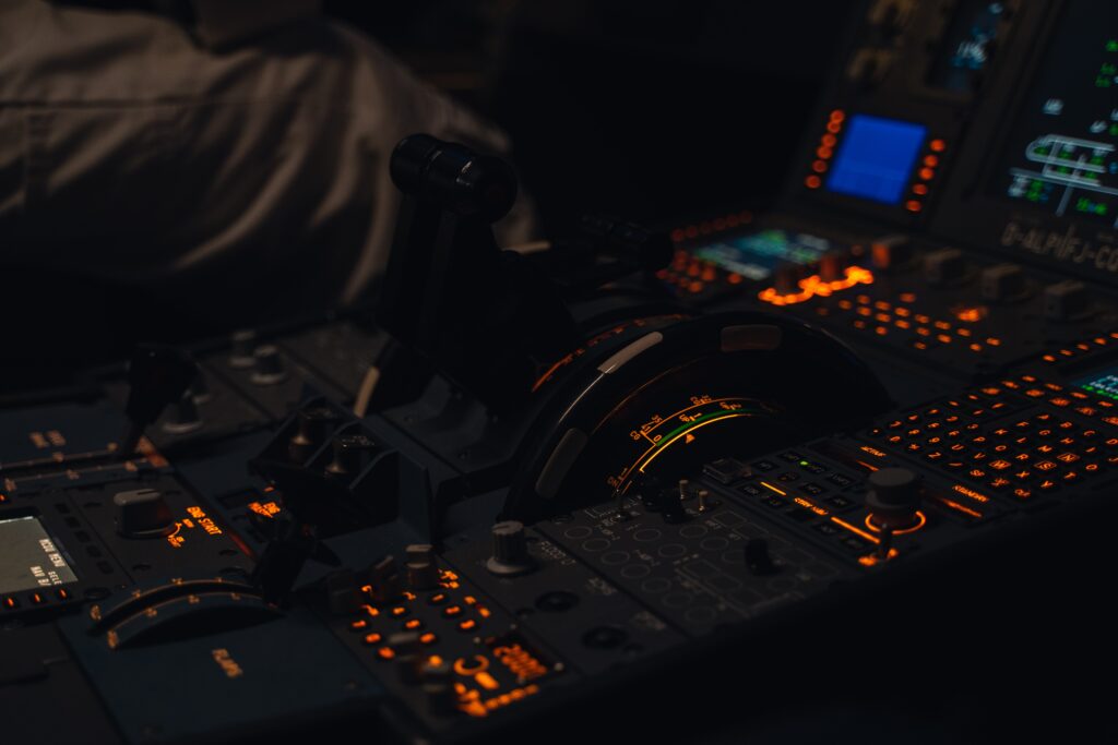 close up of the controls in between the two pilots seats of an airplane